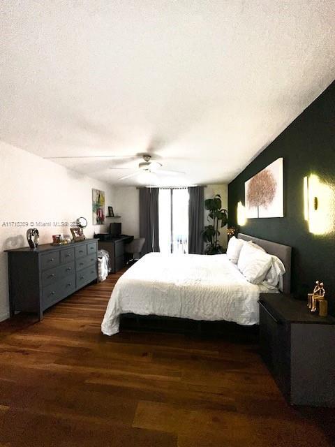 bedroom featuring a textured ceiling, dark hardwood / wood-style floors, and ceiling fan