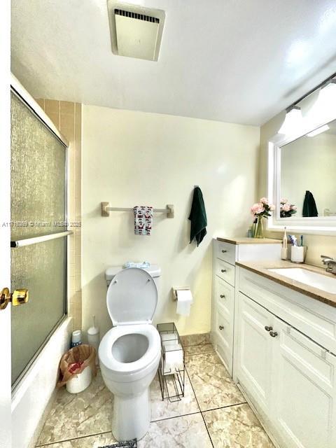 full bathroom featuring vanity, toilet, and enclosed tub / shower combo