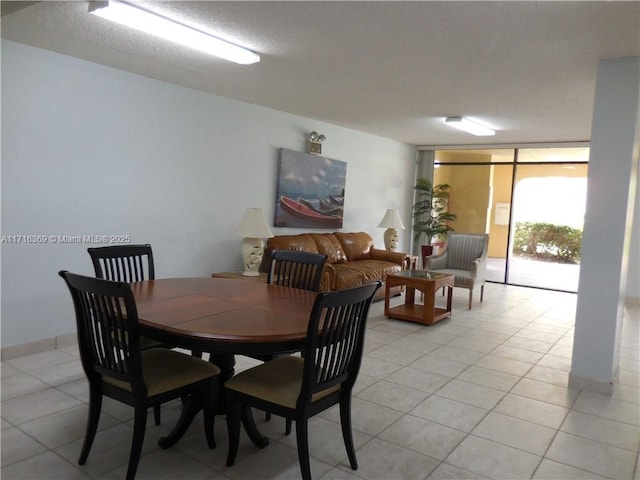 tiled dining room featuring floor to ceiling windows