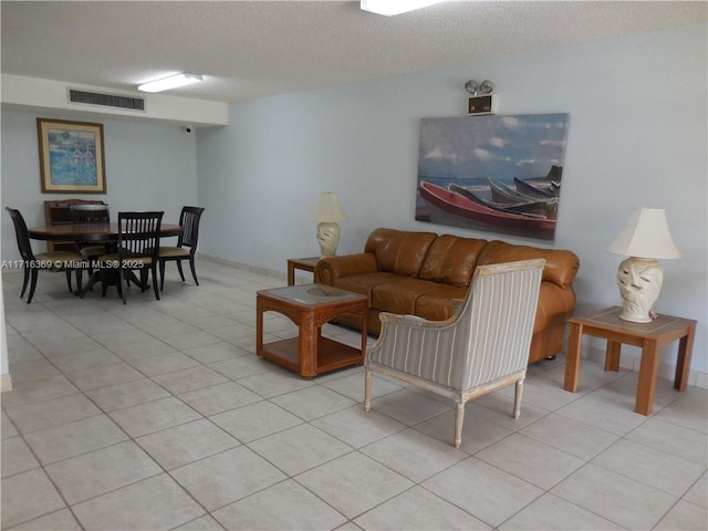 tiled living room featuring a textured ceiling