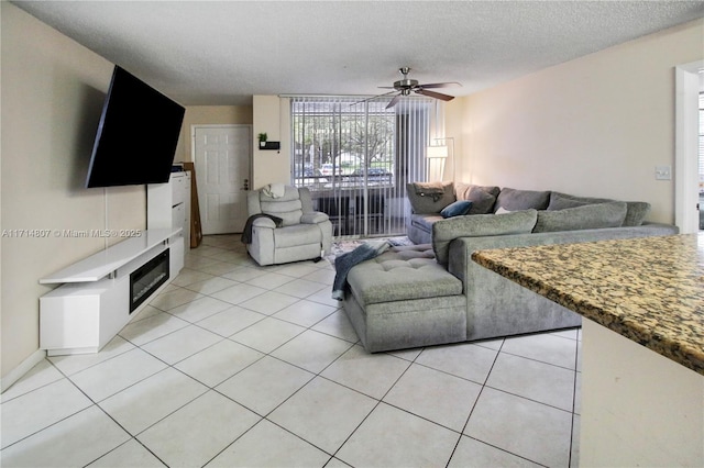 tiled living room featuring ceiling fan and a textured ceiling