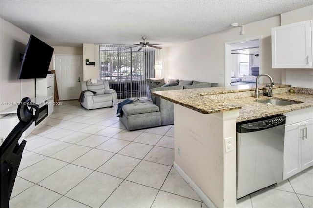 kitchen featuring white cabinetry, dishwasher, light stone counters, and sink