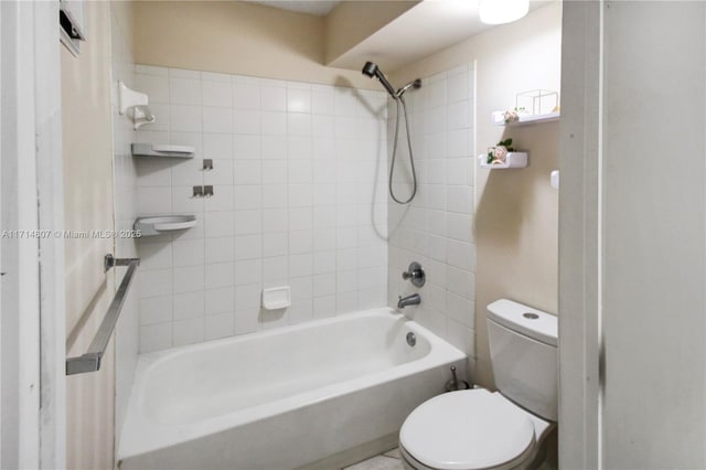 bathroom featuring tiled shower / bath combo and toilet