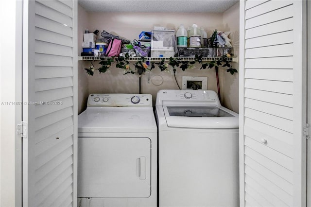 laundry room featuring a textured ceiling and washing machine and clothes dryer