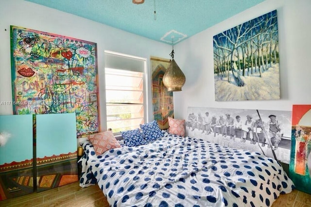 bedroom featuring hardwood / wood-style flooring and a textured ceiling