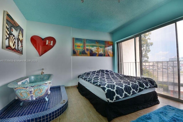 bedroom featuring hardwood / wood-style floors and a textured ceiling