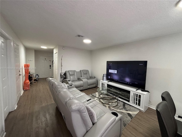 living room featuring a textured ceiling and dark wood-type flooring