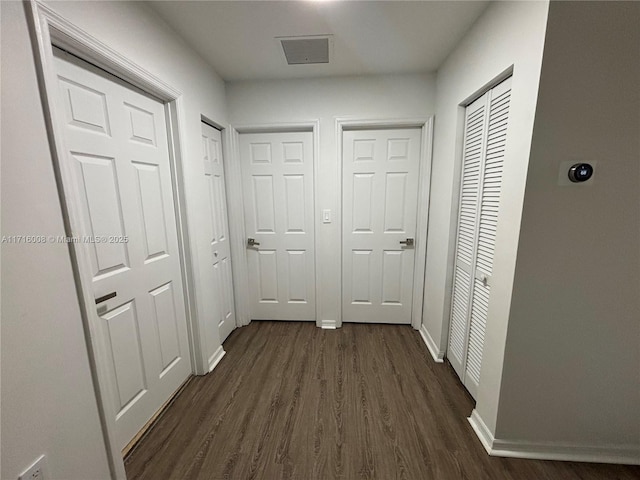 corridor with dark hardwood / wood-style flooring