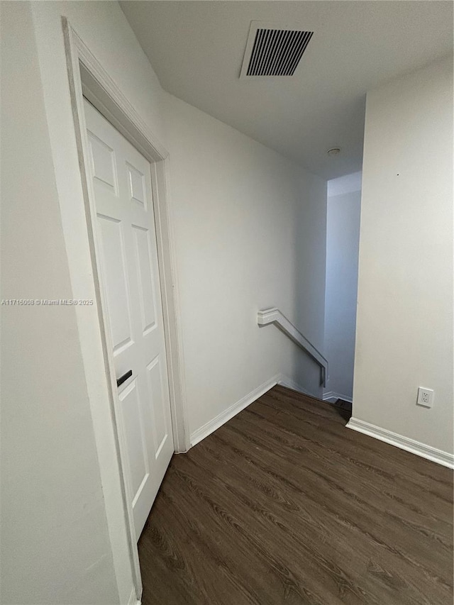 clothes washing area with dark wood-type flooring