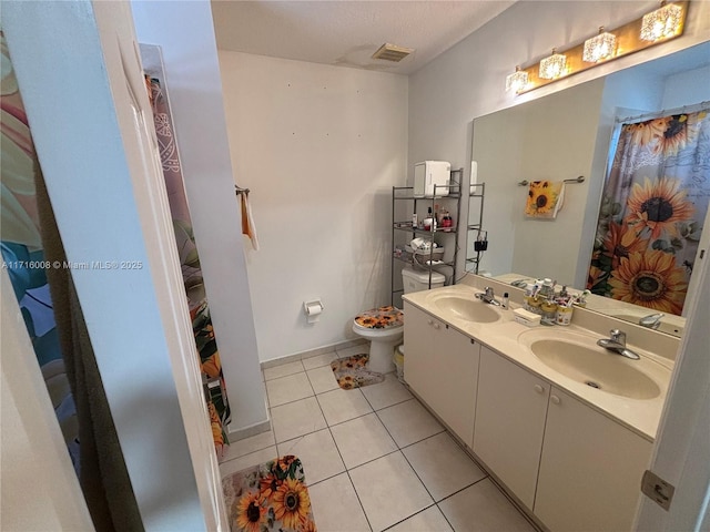 bathroom featuring toilet, vanity, and tile patterned flooring