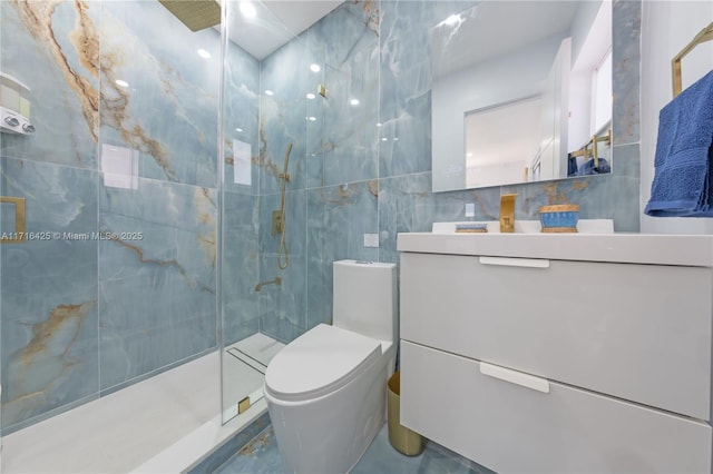 bathroom with tiled shower, vanity, tile walls, and toilet