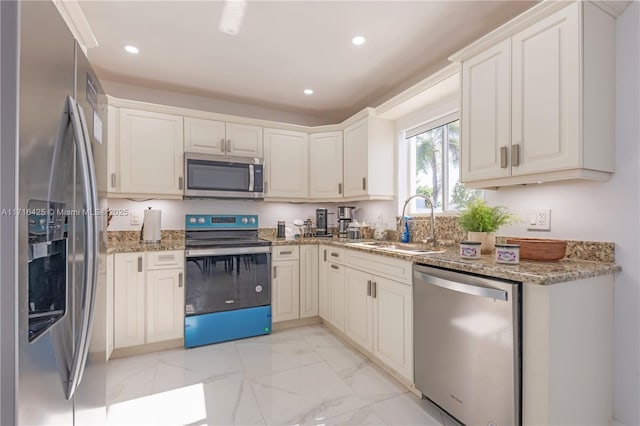 kitchen featuring stone countertops, stainless steel appliances, and sink