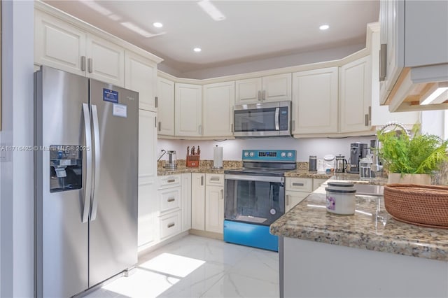 kitchen with white cabinets, light stone countertops, and stainless steel appliances