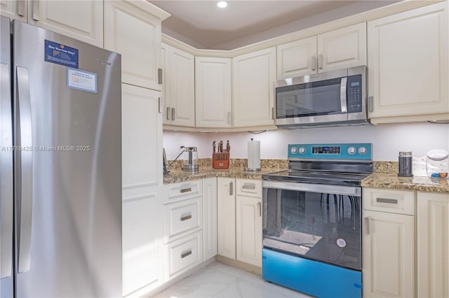 kitchen with stainless steel appliances, light stone counters, and white cabinetry