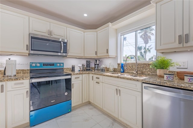 kitchen featuring white cabinets, sink, stainless steel appliances, and dark stone counters