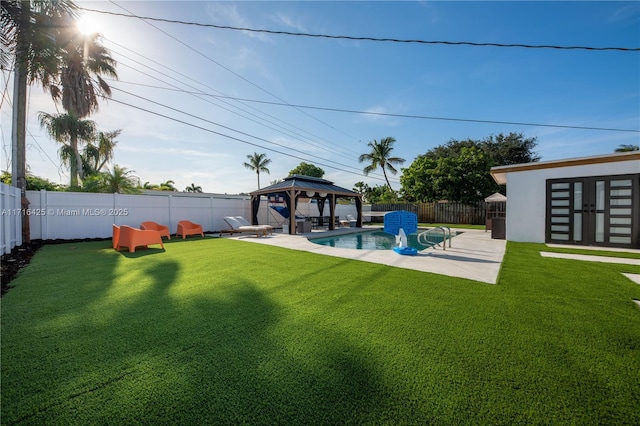 view of yard featuring a gazebo, a patio area, a fenced in pool, and an outbuilding