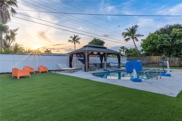 pool at dusk featuring a gazebo, a yard, and a patio