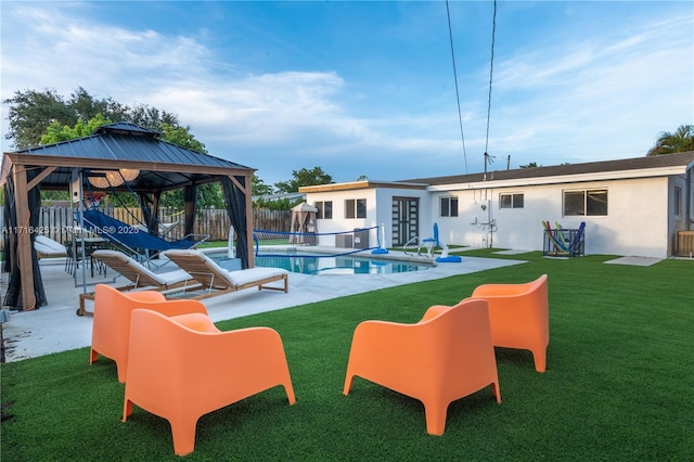 view of pool featuring a gazebo, a patio area, a lawn, and an outdoor structure