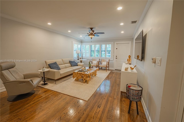 living room with hardwood / wood-style flooring, ceiling fan, and crown molding