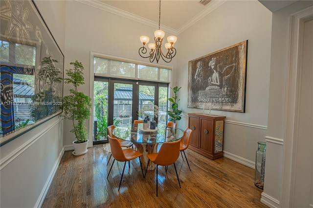 dining area featuring ornamental molding, hardwood / wood-style flooring, and a notable chandelier