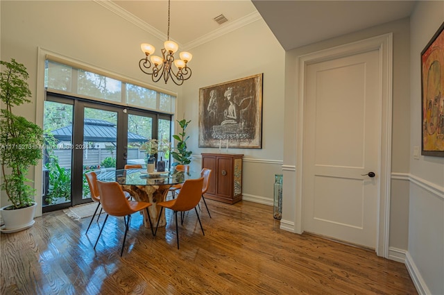 dining room with a chandelier, hardwood / wood-style floors, french doors, and ornamental molding