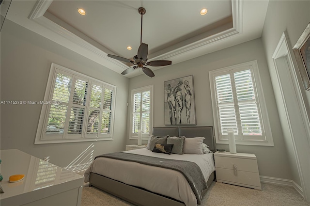 carpeted bedroom featuring a raised ceiling and ceiling fan