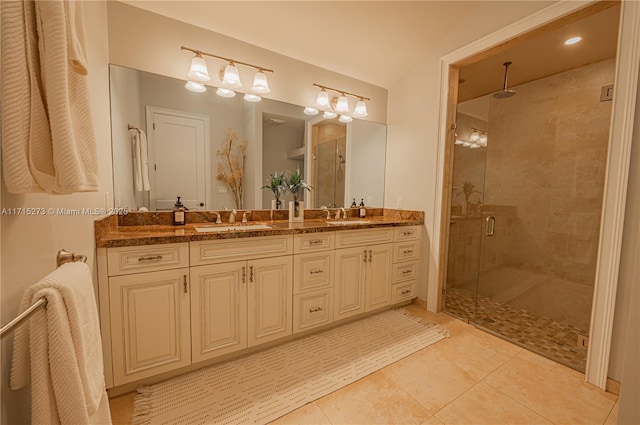 bathroom with a shower with door, vanity, and tile patterned flooring