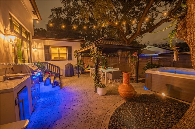 view of patio / terrace featuring a hot tub and a wet bar