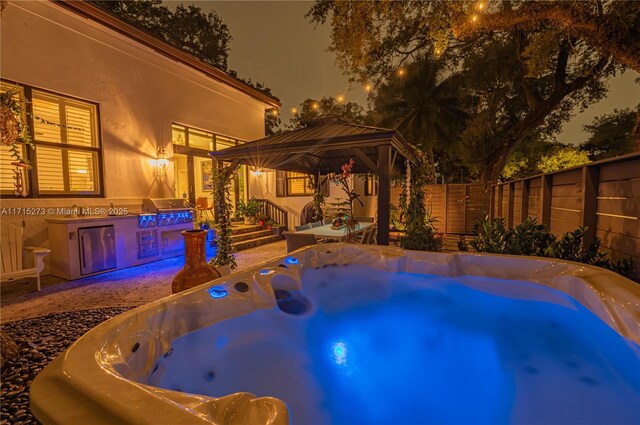 view of swimming pool featuring a gazebo and a hot tub