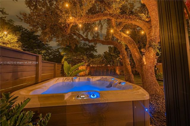 pool at twilight featuring a hot tub