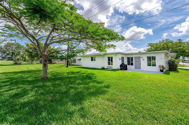 rear view of property with a yard