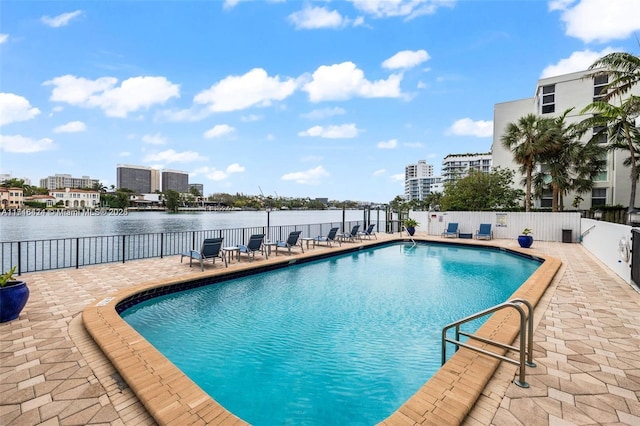 view of swimming pool with a patio and a water view