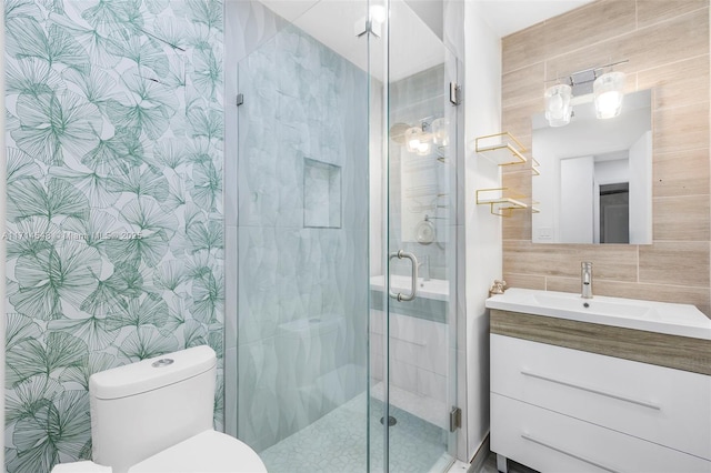 bathroom with vanity, toilet, tile walls, tasteful backsplash, and an enclosed shower