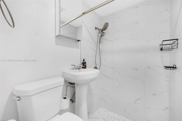 bathroom featuring a tile shower and toilet