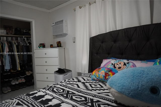 bedroom featuring an AC wall unit, a closet, and crown molding