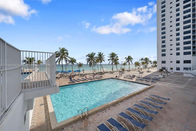 view of swimming pool with a water view and a patio