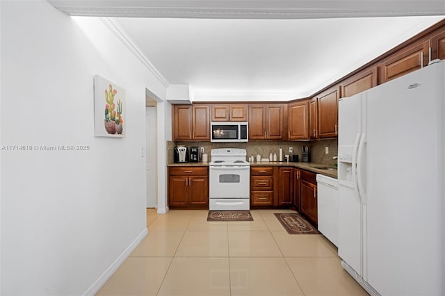 kitchen featuring light tile patterned floors, white appliances, crown molding, and backsplash