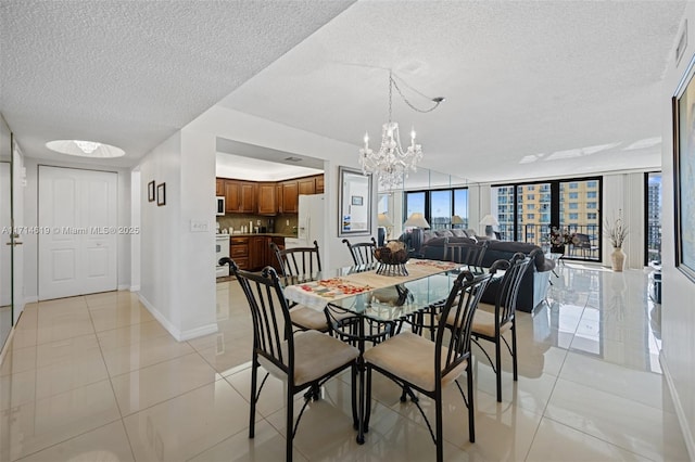 dining area with light tile patterned floors, a textured ceiling, floor to ceiling windows, and a notable chandelier