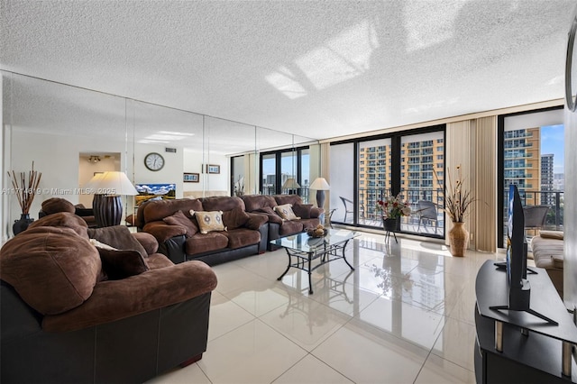 living room featuring a wall of windows, a textured ceiling, and light tile patterned floors