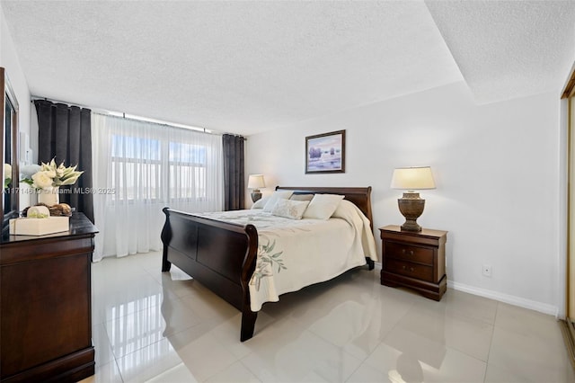 bedroom with light tile patterned floors and a textured ceiling