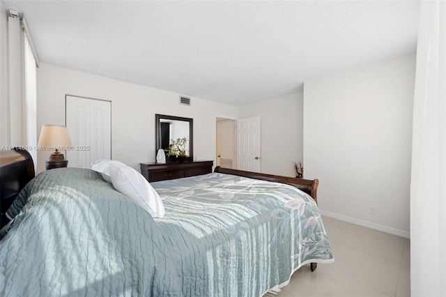 bedroom with light tile patterned flooring and a closet