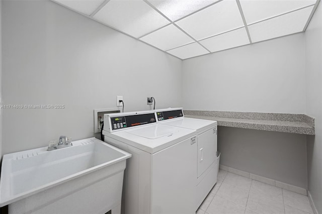 laundry room featuring light tile patterned floors, sink, and washing machine and clothes dryer