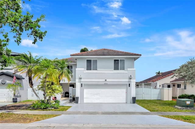 view of front of house featuring driveway, a gate, fence, a garage, and a tiled roof
