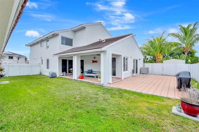 rear view of property with a lawn, a fenced backyard, and a patio area