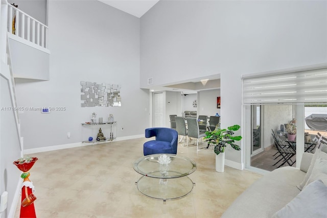 sitting room featuring baseboards and a towering ceiling