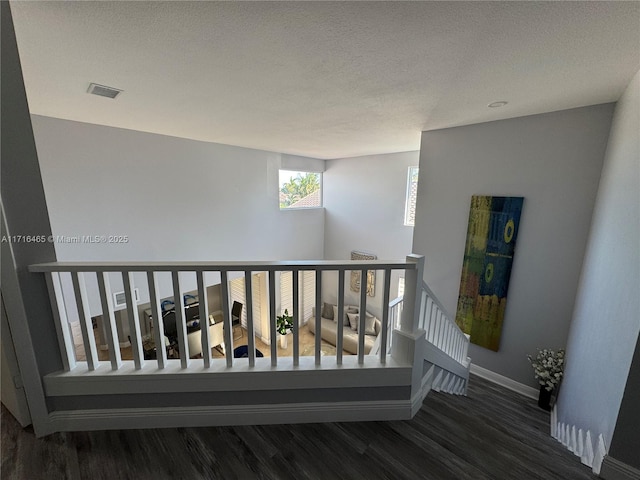 staircase featuring hardwood / wood-style flooring and a textured ceiling