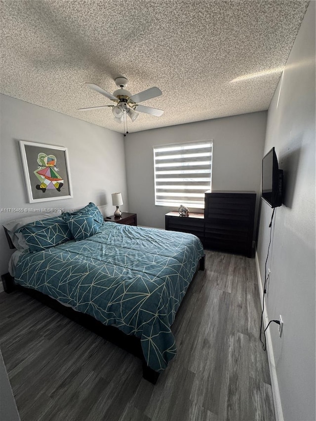 bedroom with ceiling fan, dark hardwood / wood-style floors, and a textured ceiling