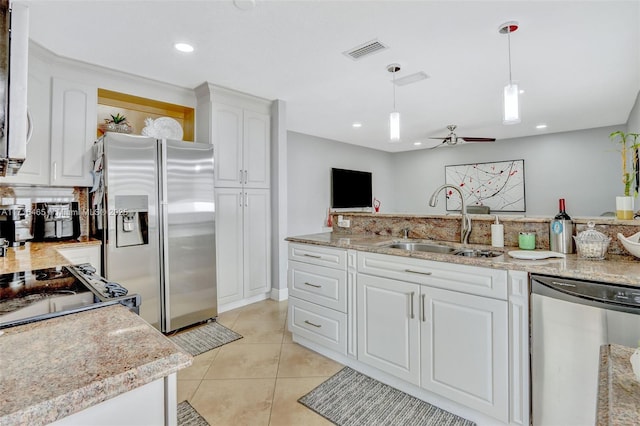 kitchen featuring visible vents, decorative light fixtures, stainless steel appliances, white cabinetry, and a sink