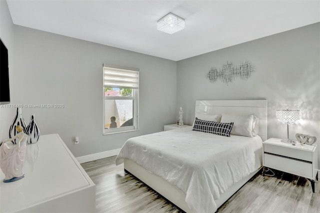 bedroom featuring wood finished floors and baseboards