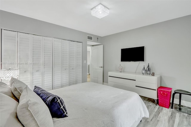 bedroom featuring visible vents, baseboards, and wood finished floors